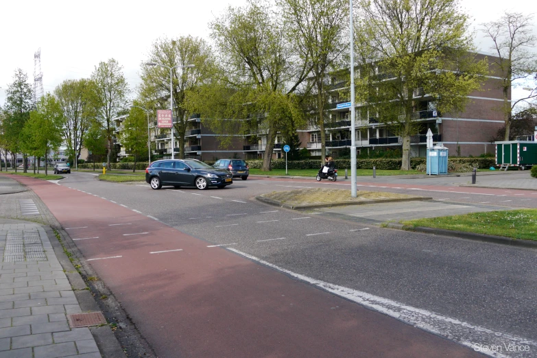 a car passing by a red traffic light next to a road