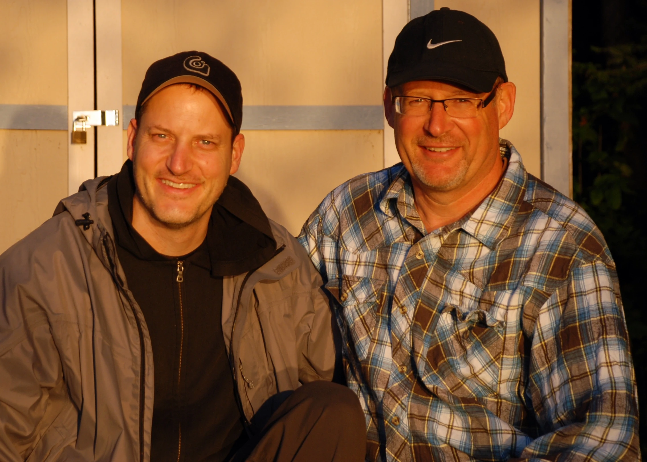 two guys that are sitting in front of a door