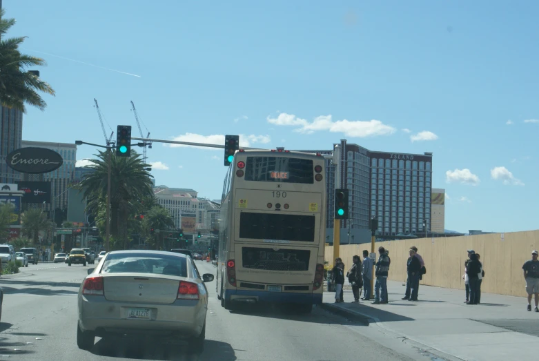 the bus is approaching in the middle of traffic