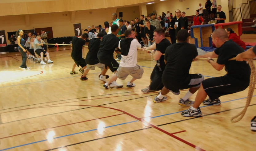 people in a gymnasium holding tennis rackets