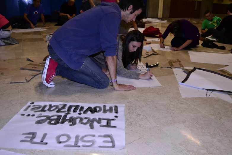two people sit in a room with writing on the floor