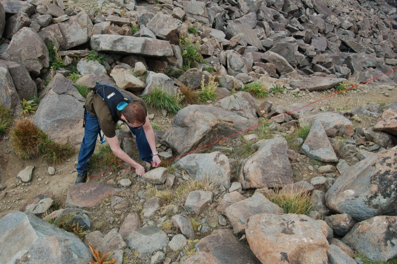 a man working on large rocks in the mountains