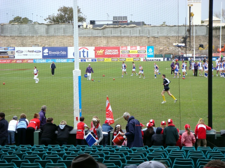 a soccer field with fans and several players