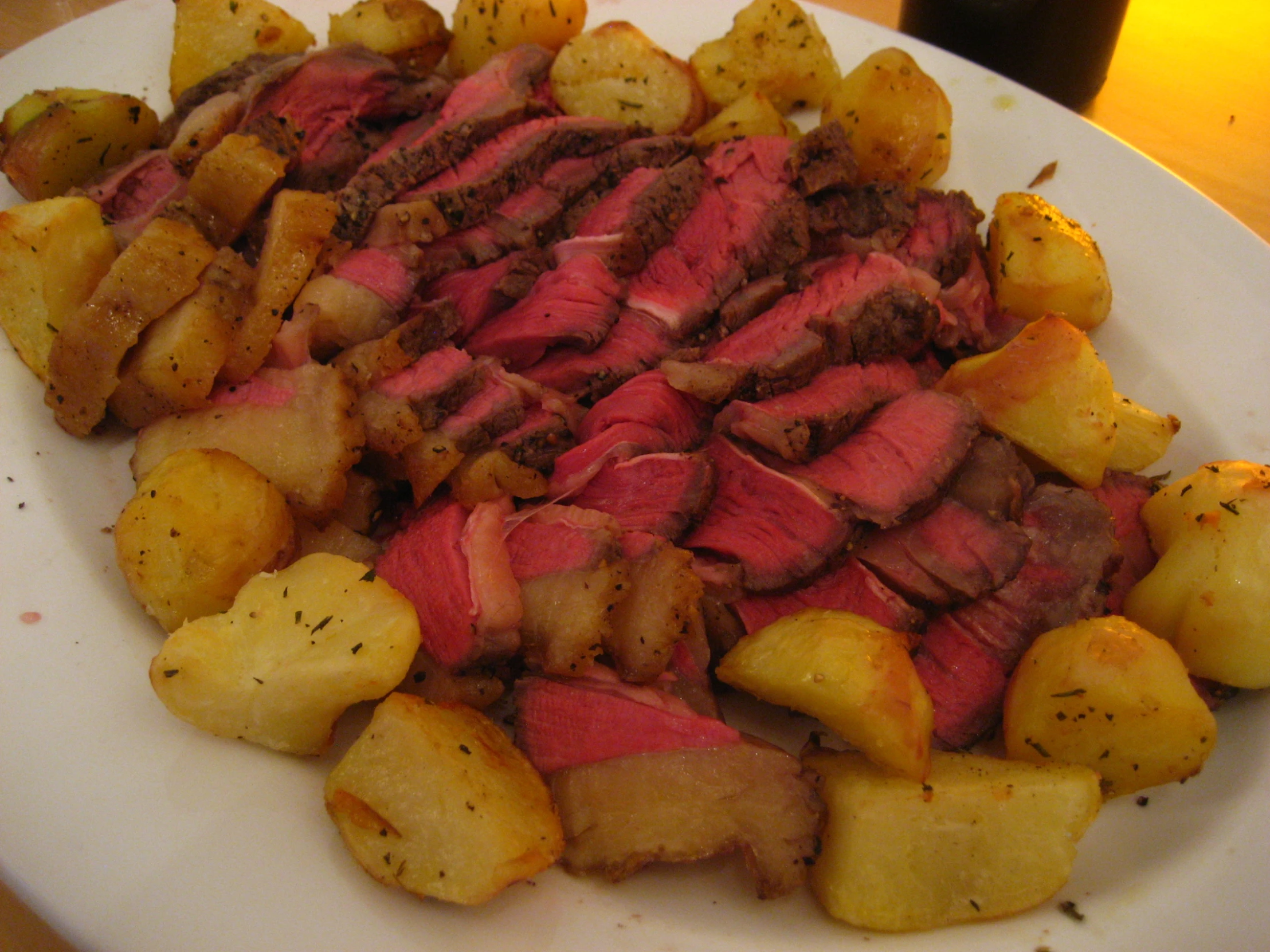 a large plate of potatoes and beef with meat