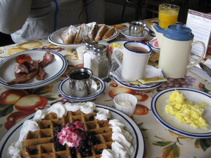 the table is covered with many breakfast foods