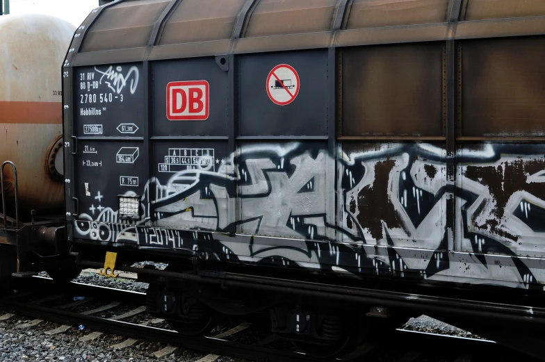 an old black train is covered in spray paint