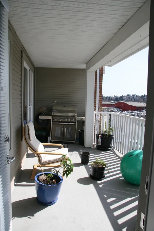 a balcony has a white bench and a grill on it