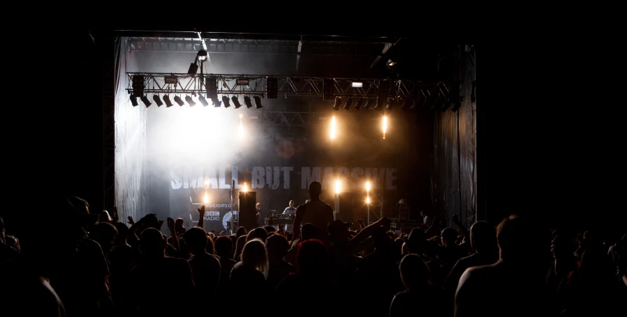 a concert with several people on the stage and one man on the microphone