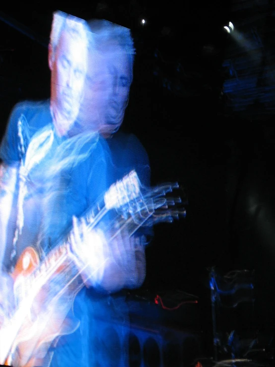 a man is playing his guitar while people stand around