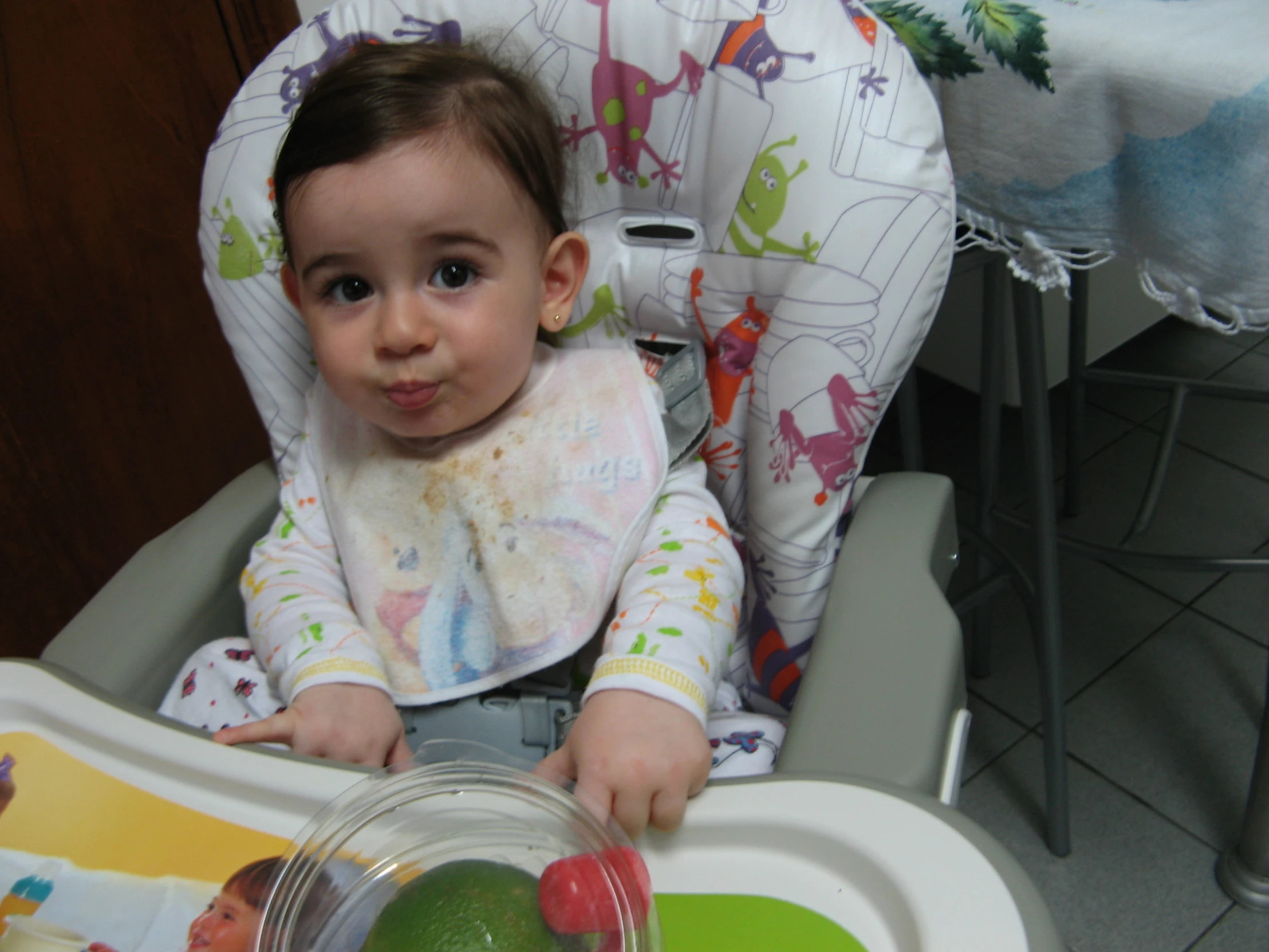 a  is sitting in her high chair