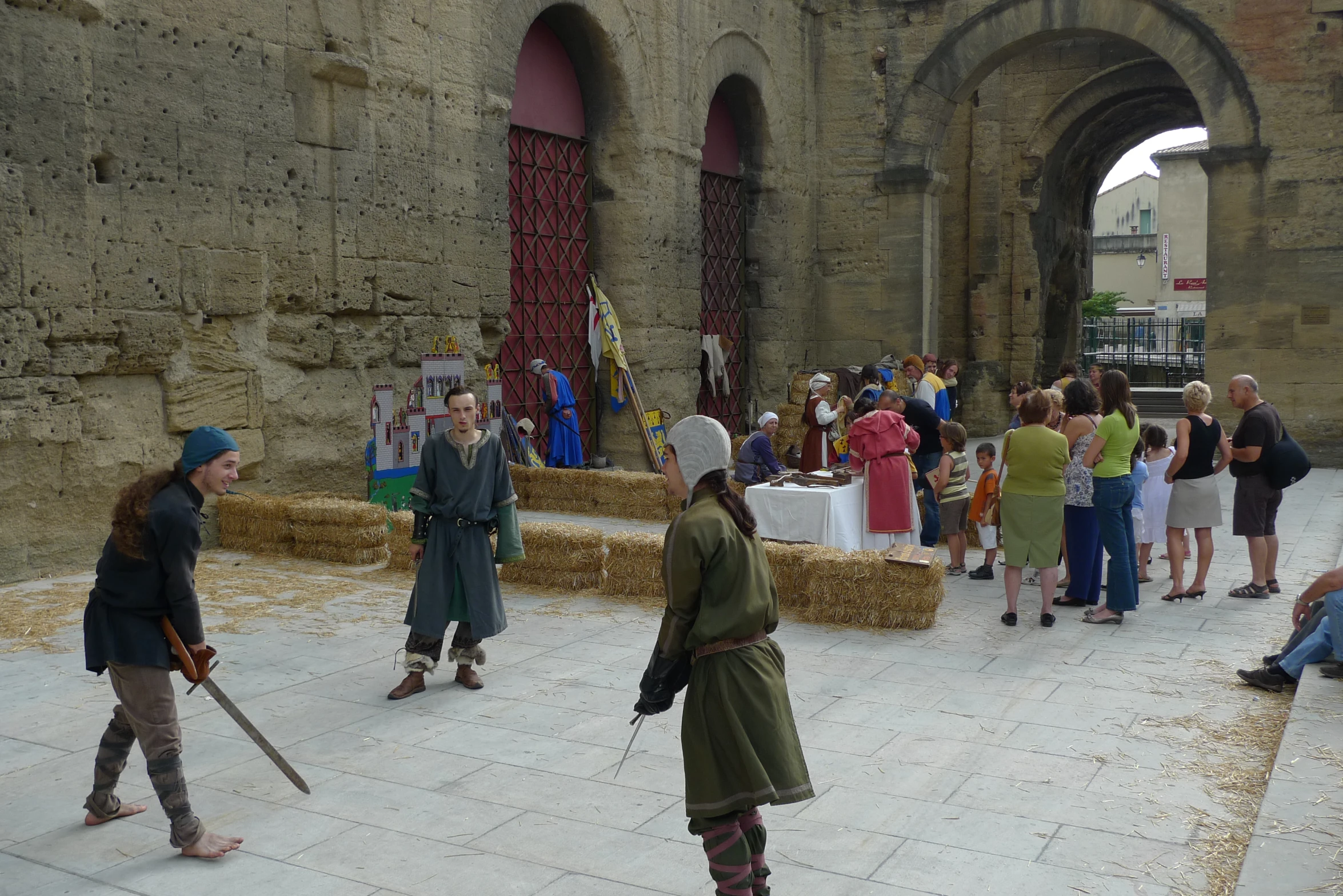 two knights dressed in costumes walking past a crowd of people