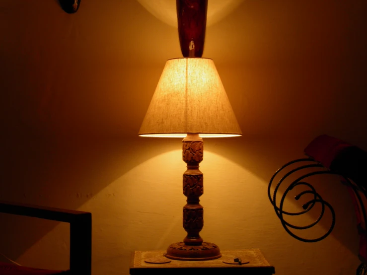 an empty lamp stands between the two wall sconces
