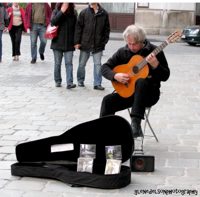 a person sitting down with a guitar