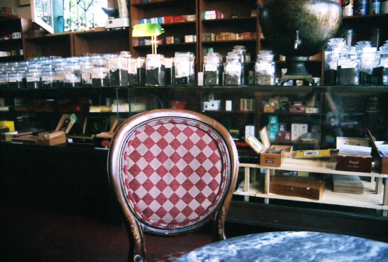 a red and white checkered chair sitting in front of a store
