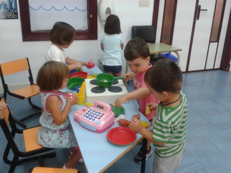 children in kitchen cooking with child size toys