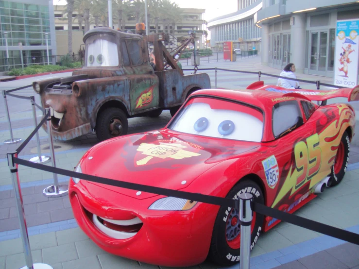 a red car parked next to another old car