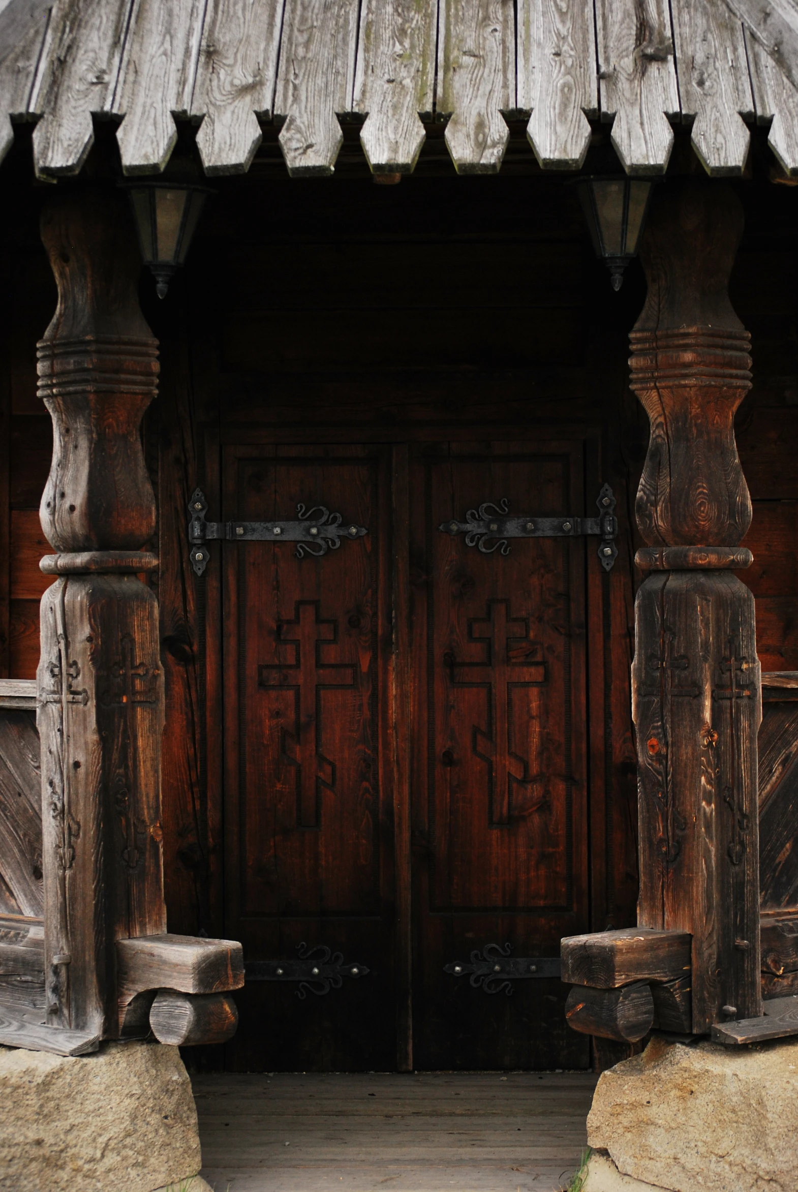 a large brown door and some wooden pillars