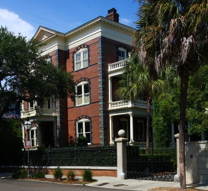 a building with wrought iron fencing sits behind a gate