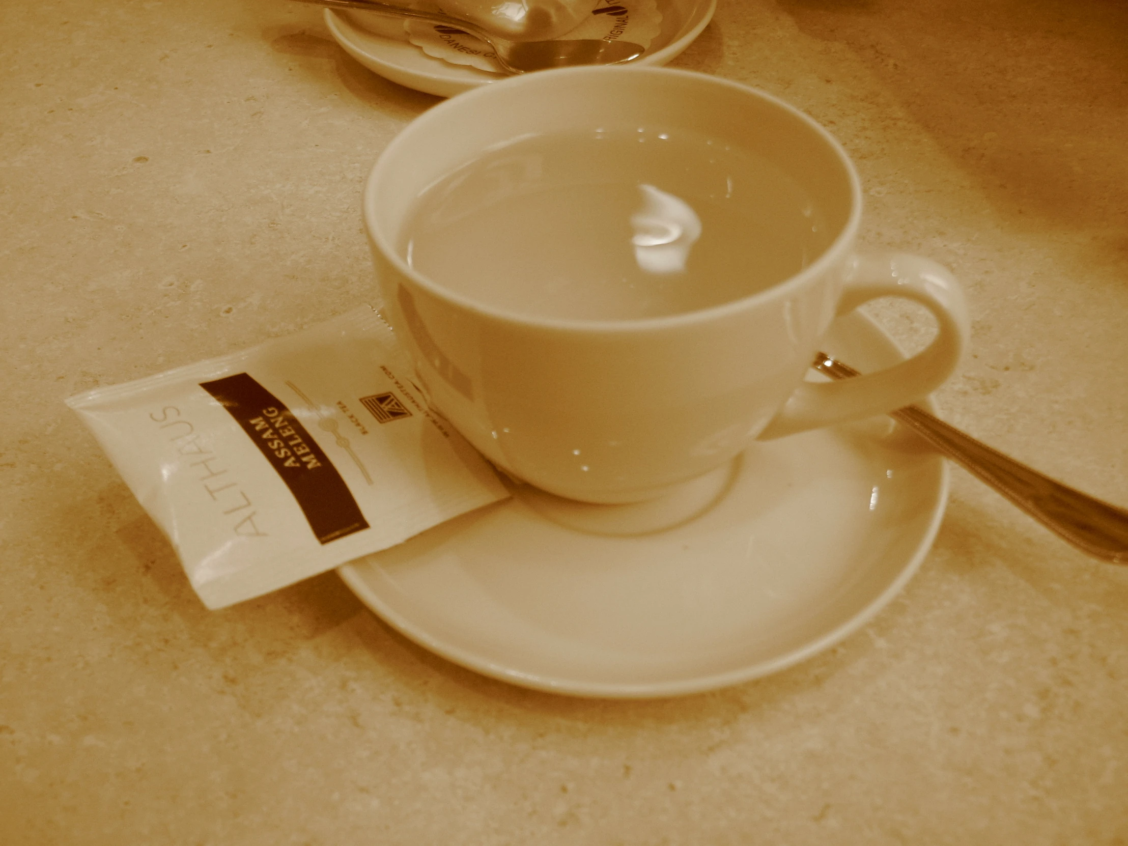 a small cup and saucer sitting on a plate