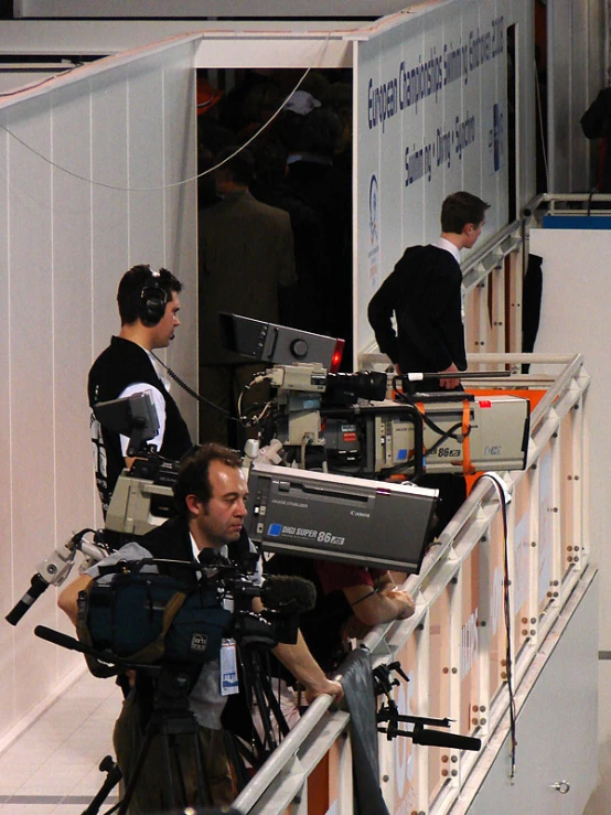 three men and a woman on a set of media equipment