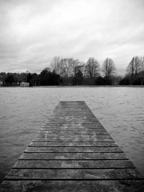 a long, wooden pier stretches out into a lake