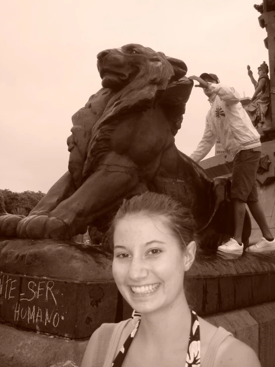 the woman is posing for a picture with a statue