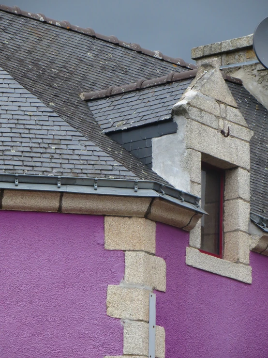 the old roofs of an older building are yellow and purple