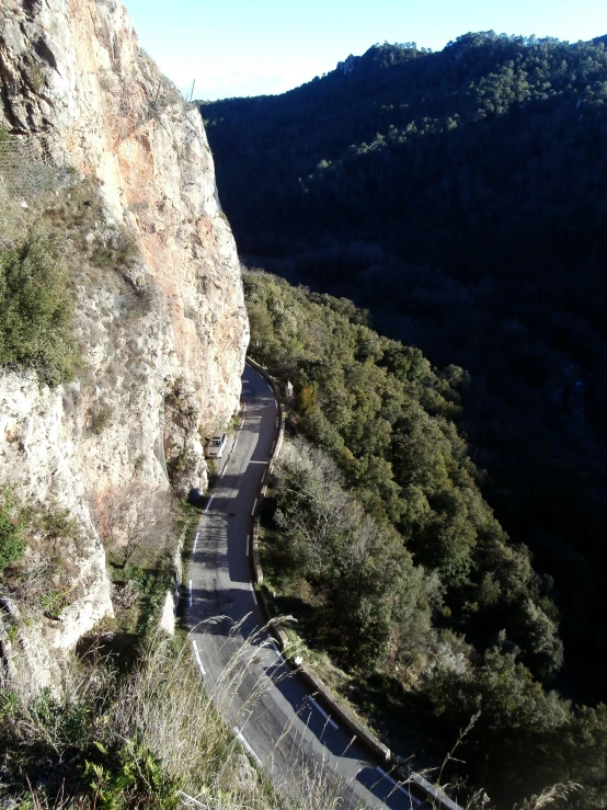 a road runs between a cliff and some hills