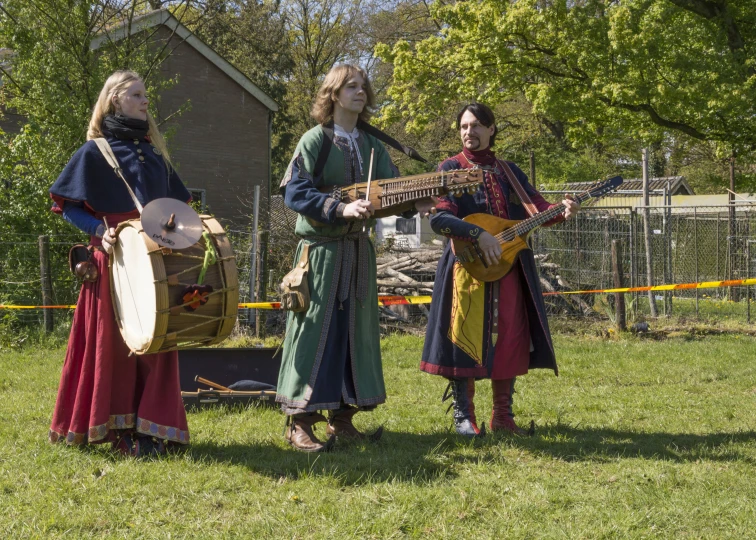 three people dressed in costume playing instruments and singing