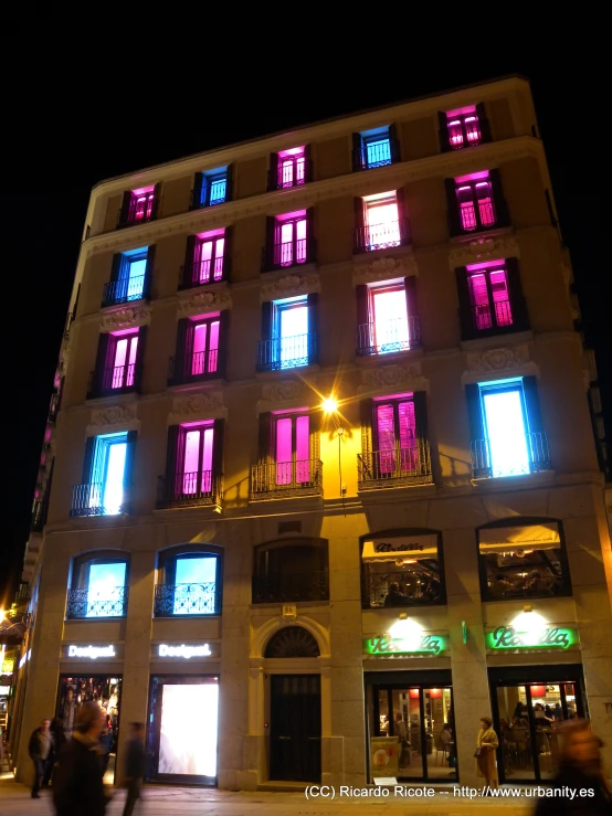 the brightly colored windows of an apartment building at night