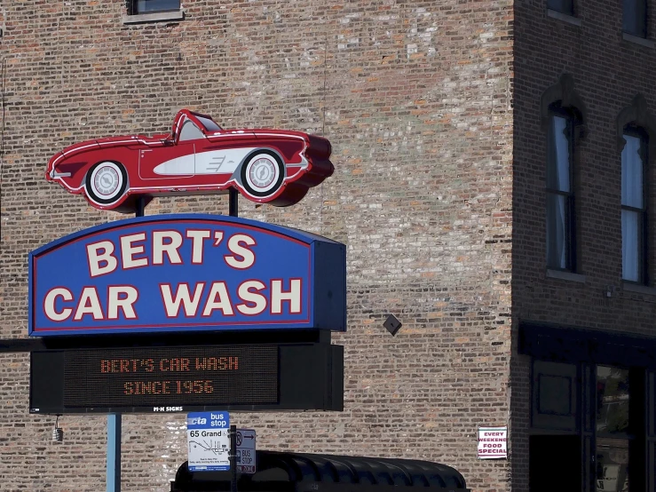 a large car wash sign hangs on the side of a building