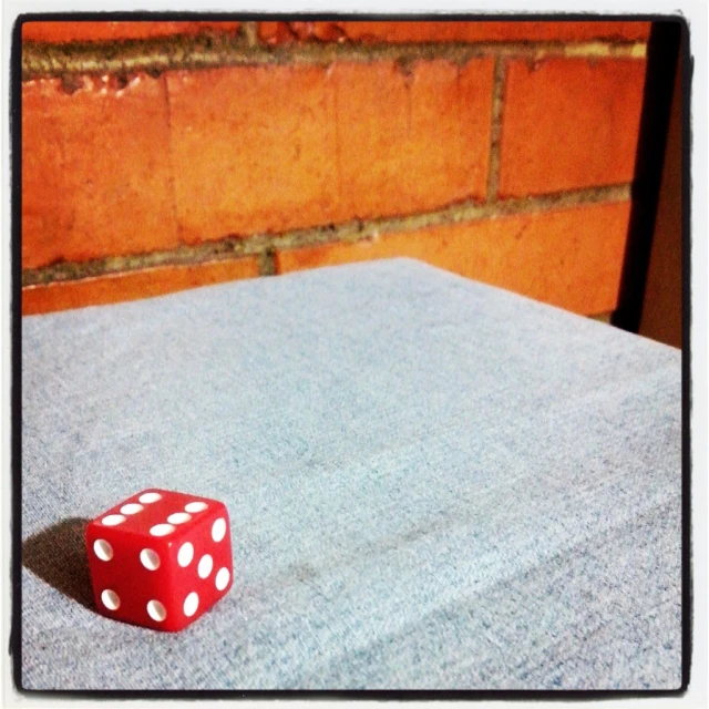 red dice on blue cloth sitting on top of a wooden table