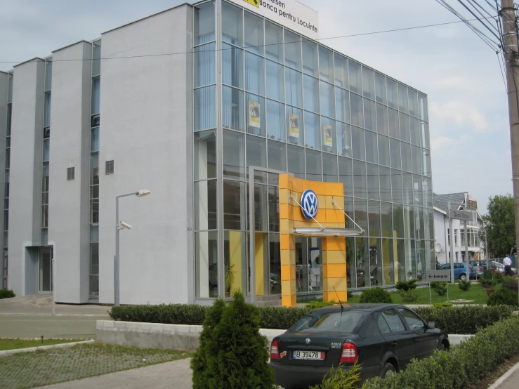 a car sits parked outside of a large building