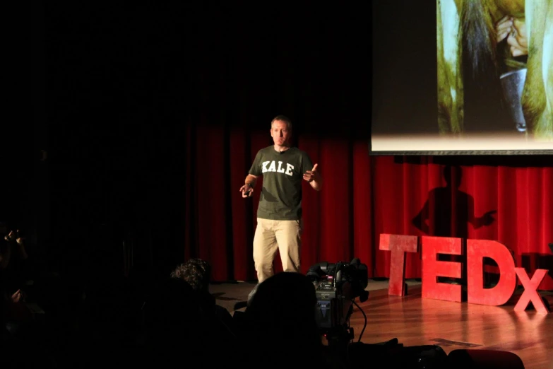 man presenting a ted talk at an event