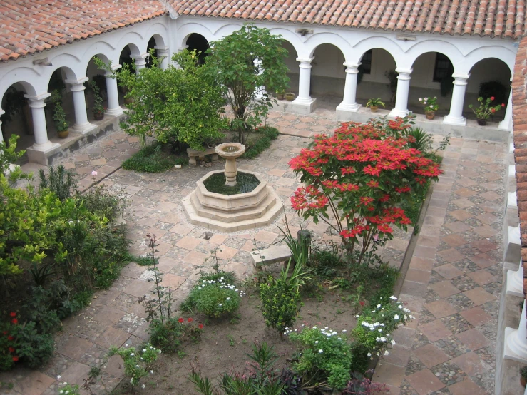 a courtyard with several benches and colorful trees