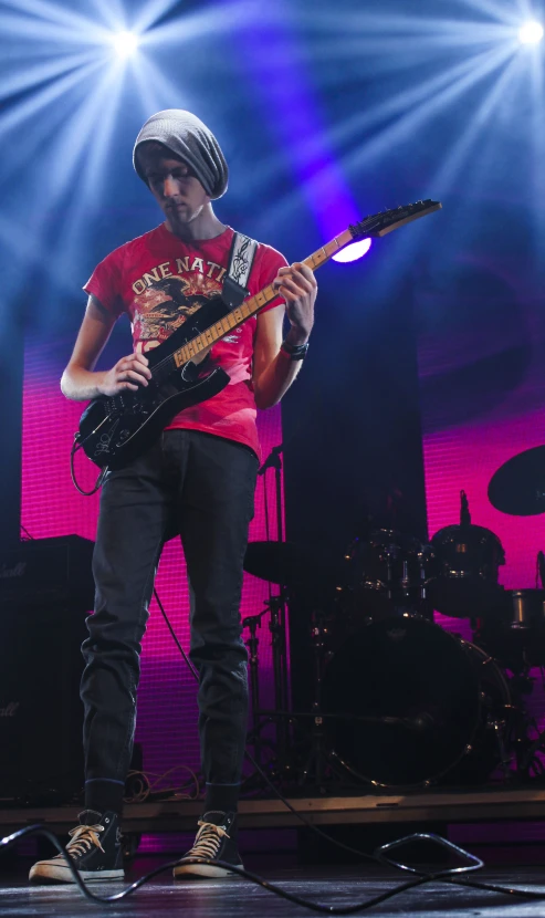 a man standing on stage playing an electric guitar
