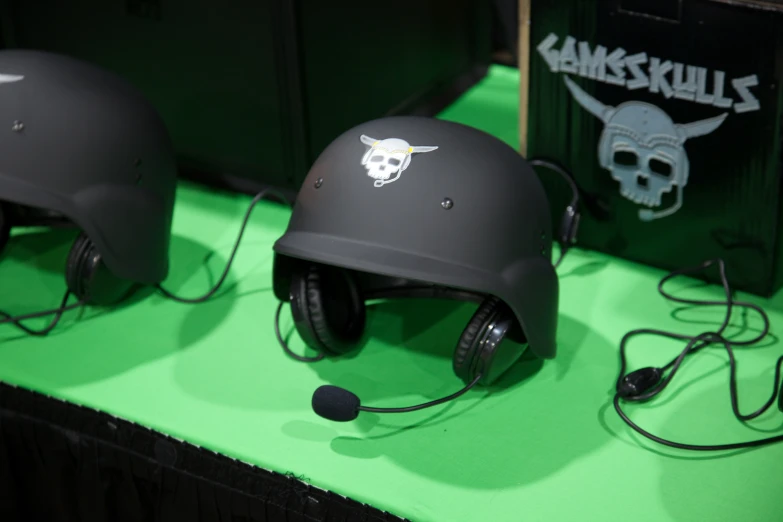 three helmet headset and a book cover sit on a green surface