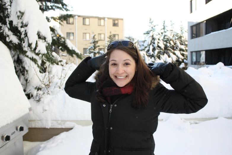 a woman with snow and her sunglasses on in front of some trees