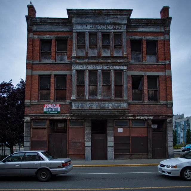 two cars are parked next to an old building