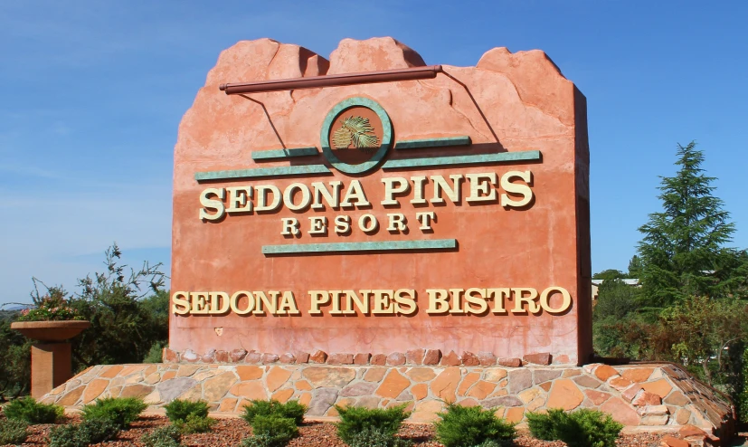 sedona pines resort sign with a piney forest in the background
