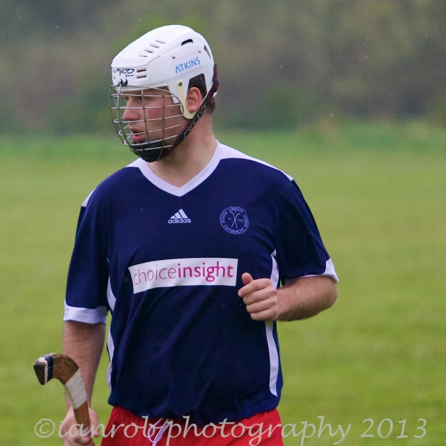 a man is holding a stick with a mask on