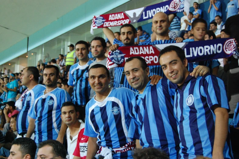 a large group of people in a crowd, some holding signs