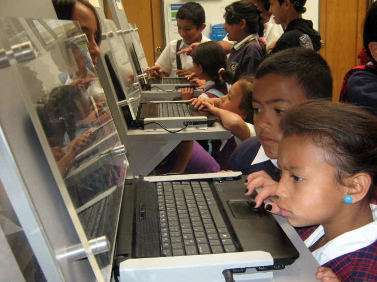 children looking at the screen of a laptop computer