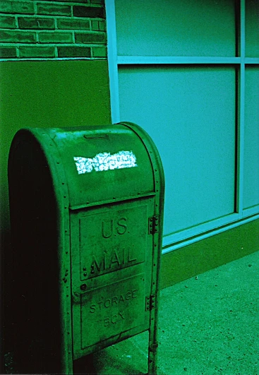 a large green steel mailbox outside an office