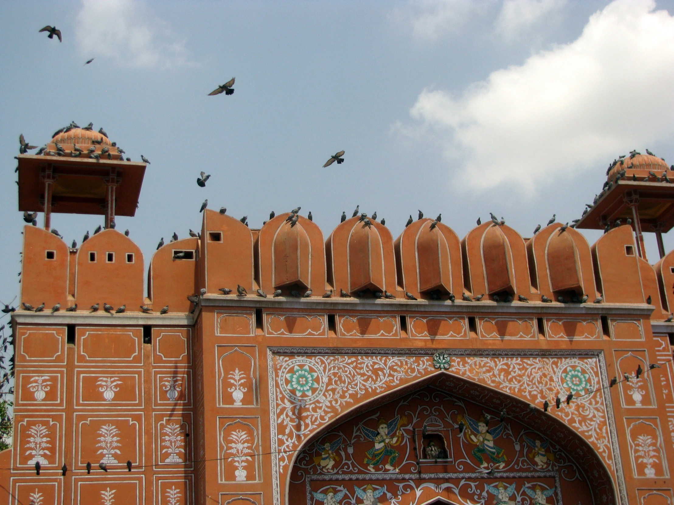 a building with multiple windows and ornate designs and birds on top