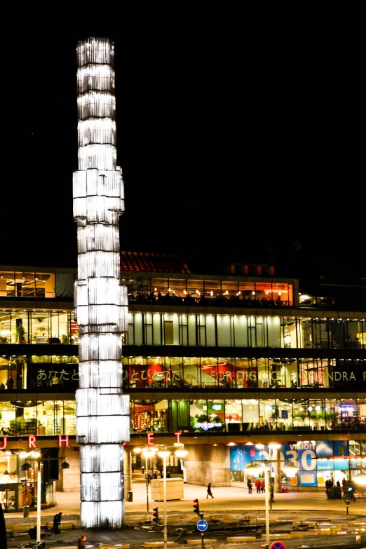 a tall light tower is lit up at night