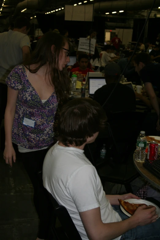 two people sitting at a table with pizza