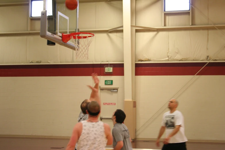 a man with a basketball in his hand goes up to hit it