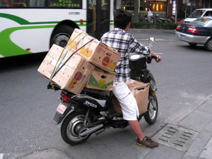 a man with a box sitting on a motorcycle