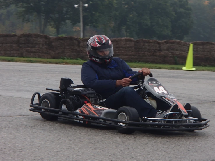 a man riding a go kart racing car on top of a track